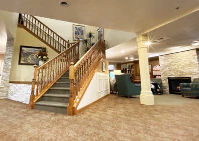 Grand staircase and living room with a fireplace in pueblo